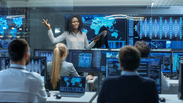 Chief Project Engineer Holds Briefing for a Team of Scientists that are Building Machine Learning System. Displays Show Working Model of Neural Network.